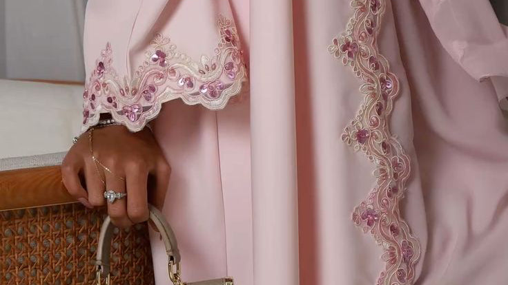 Abaya Pétale de Hinari Couture : une robe rose pastel avec des broderies en dentelle perlée délicate, coupe longue et fluide, idéale pour une tenue de fête élégante et modeste.