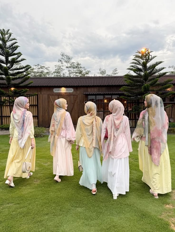 Groupe de femmes portant la collection complète Hinari Couture : les abayas Solaire jaune, Pétale rose, Sauge vert et Horizon bleu pastel avec dentelle. Des robes fluides et amples accompagnées de hijabs en soie assortis pour un style mode modeste élégant.